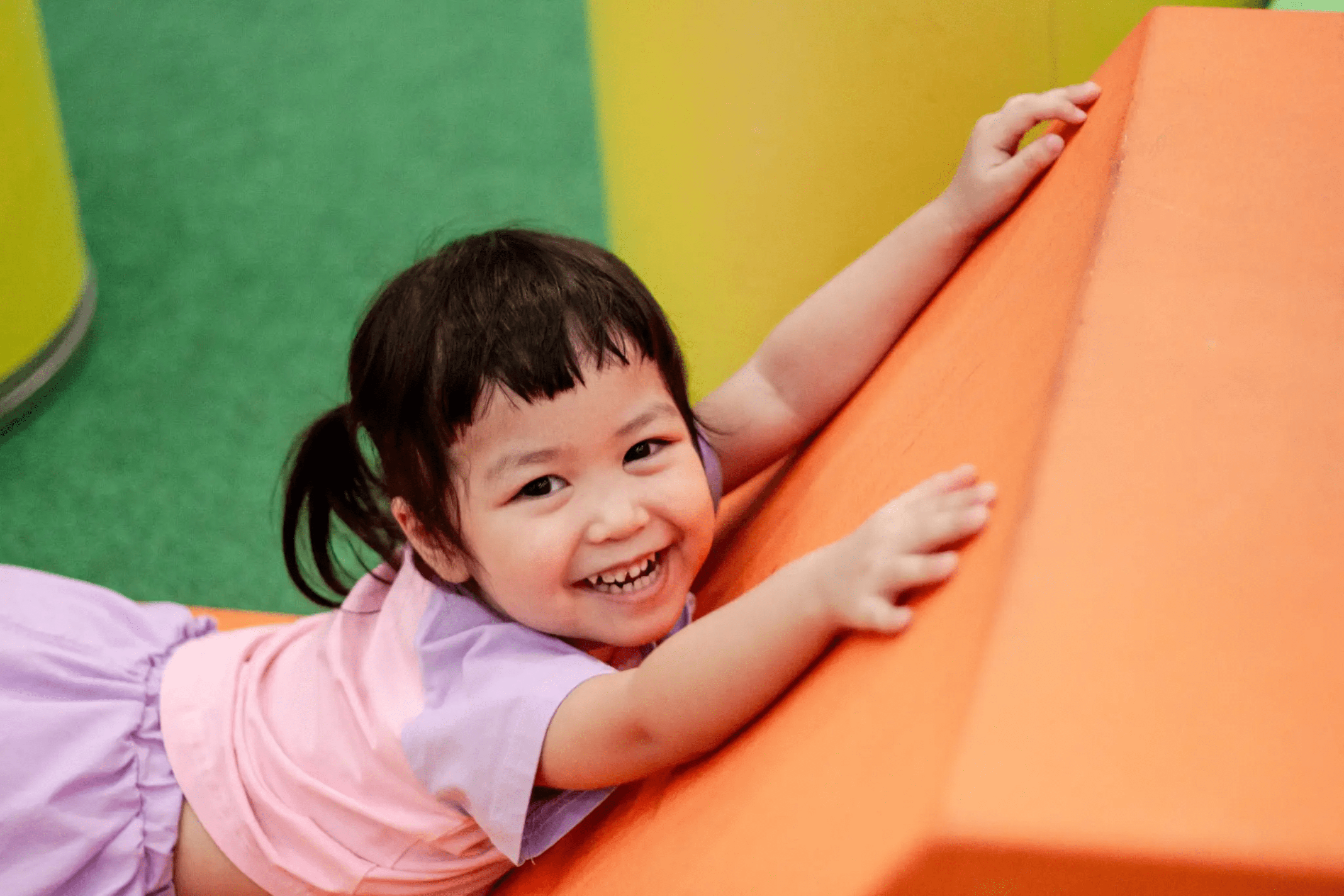 blob-81e1076 A little girl is smiling while leaning on the wall.