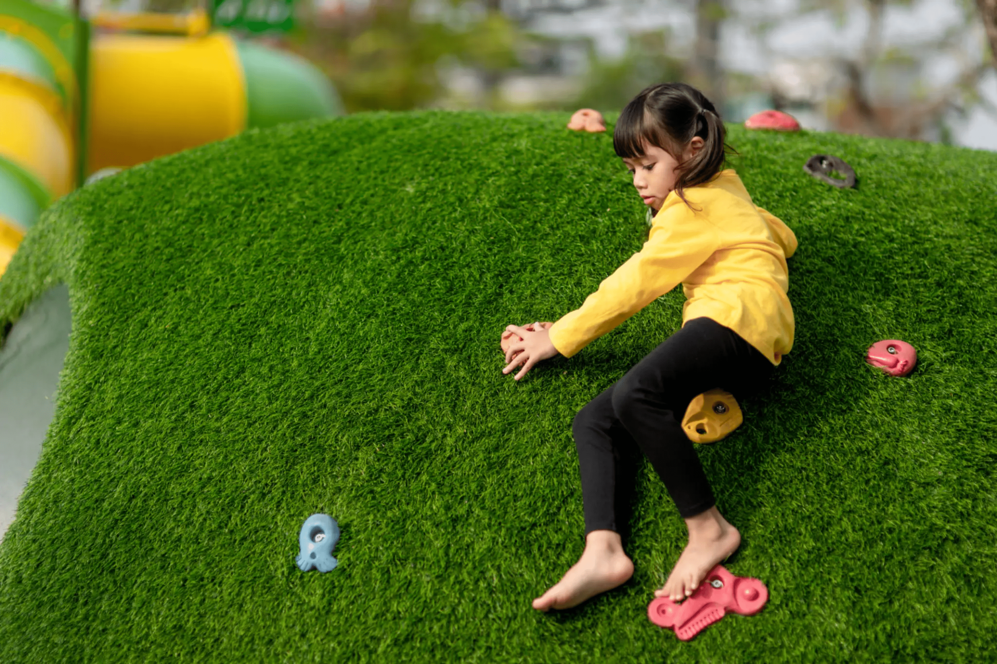 blob-b59dc86 A little girl sitting on the grass with her feet up.